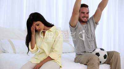 Woman getting annoyted while her boyfriend watching football match