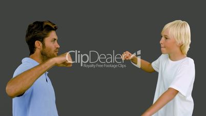 Father and son hitting their fists together on grey background