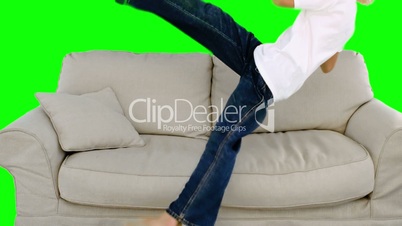 Boy jumping on the sofa on green screen