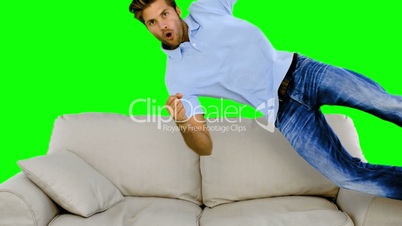 Man jumping on the sofa on green screen
