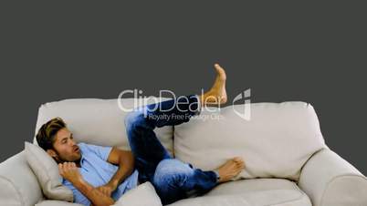 Man jumping on the sofa on grey background