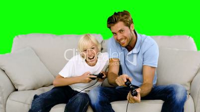 Father and son playing video games on the sofa on green screen