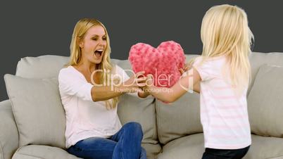 Little blond girl offering a heart to her mother in slow motion