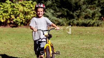 Proud child walking with his bicycle