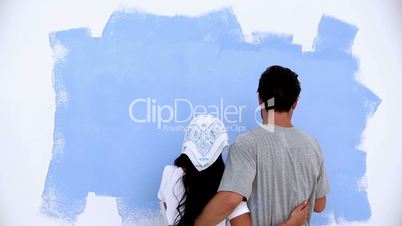 Lovely couple painting a wall