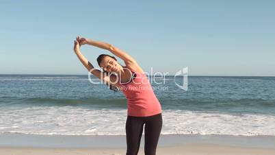 Attractive woman stretching on the beach