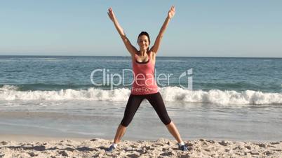 Happy woman working out on the beach