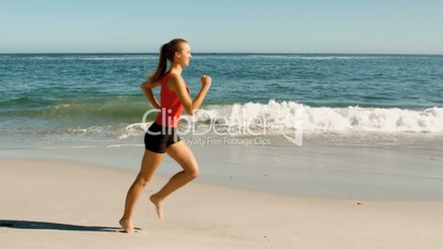 Woman with red tank top running on the beach