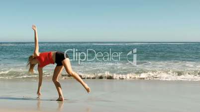 Woman doing a cartwheel on the beach