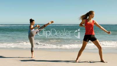 Two women doing martial arts on the beach