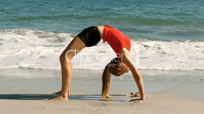 Woman practicing gymnastic at the beach