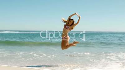 Attractive young woman jumping on the beach