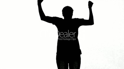 Silhouette of a man jumping with raised arms on white background