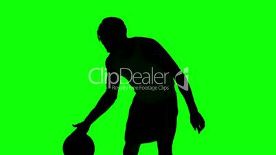 Silhouette of a man playing basket on green screen