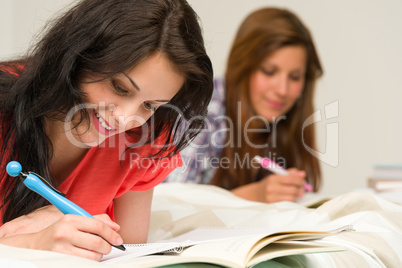 Young teenager girls studying on bed