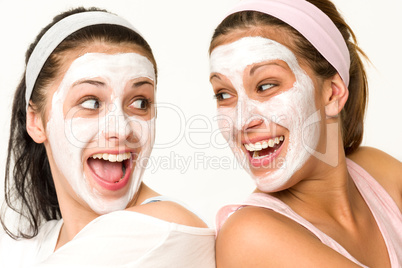 Cheerful girls having facial mask and laughing