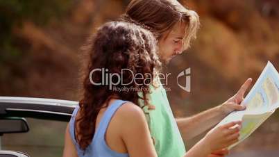 Couple reading map on side of the road