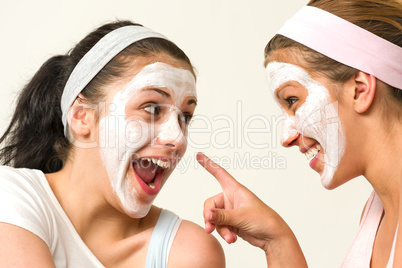 Two girls with cosmetic mask laughing