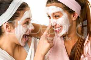 Playful teen wearing mask touches friend's nose