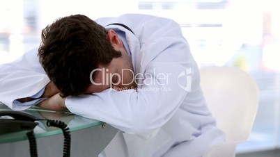 Young doctor sleeping on a desk