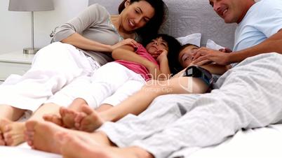 Family playing together on a bed
