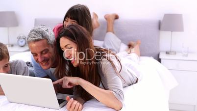 Family lying with laptop