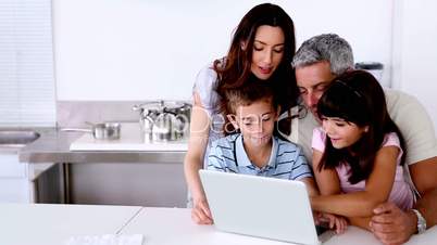 Family looking at laptop on the kitchen