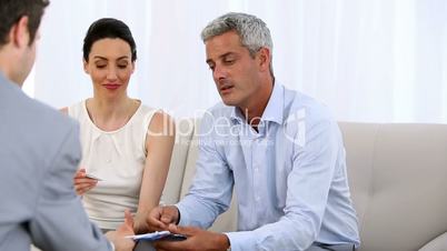 Couple signing a contract given by a salesman