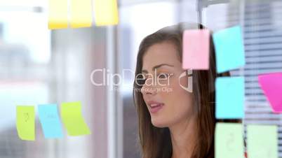 Woman writing on sticky note