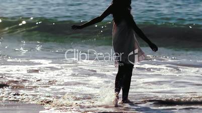 Silhouette of woman revolving in waves