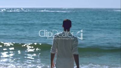 Handsome man walking towards the sea