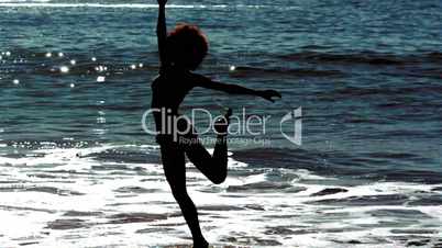 Woman jumping while she is into the sea