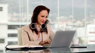 Smiling businesswoman using her laptop