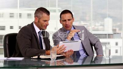 Businessmen working together on a tablet