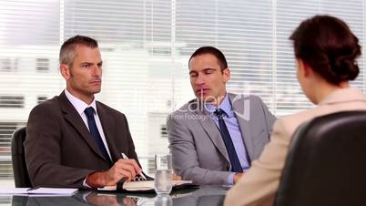 Businessmen talking to an applicant
