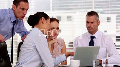 Businesswoman showing her colleagues something on the laptop