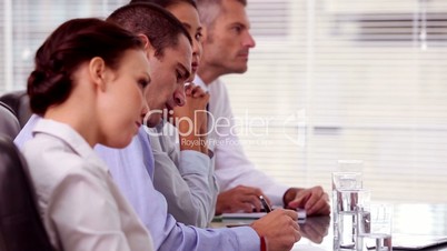 Business people taking notes during a meeting
