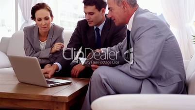 Business people on a couch working on a laptop