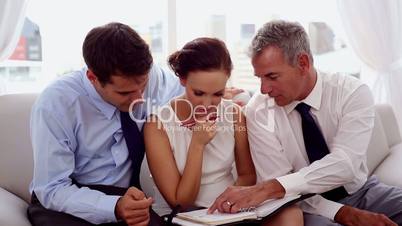 Businessmen pointing at a colleagues diary