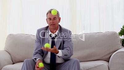Businessman playing with tennis ball