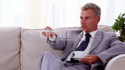 Smiling businessman drinking a cup of tea