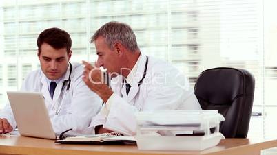 Doctor showing and explaining something to his colleague