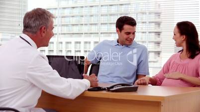 Smiling doctor explaining something to patients