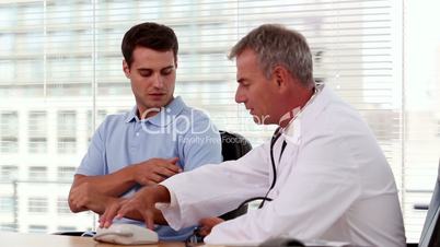 Doctor taking blood pressure of a patient
