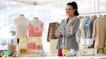 Pretty fashion designer standing with arms crossed