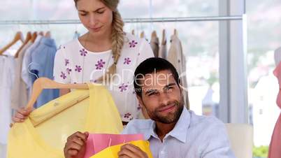 Man being annoyed by his girlfriend doing shopping