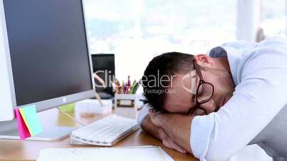 Creative designer napping on his desk