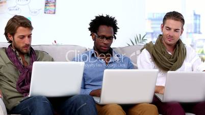 Three colleagues using laptop