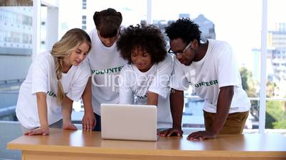 Group of volunteers using laptop together