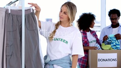 Pretty volunteer looking at clothes